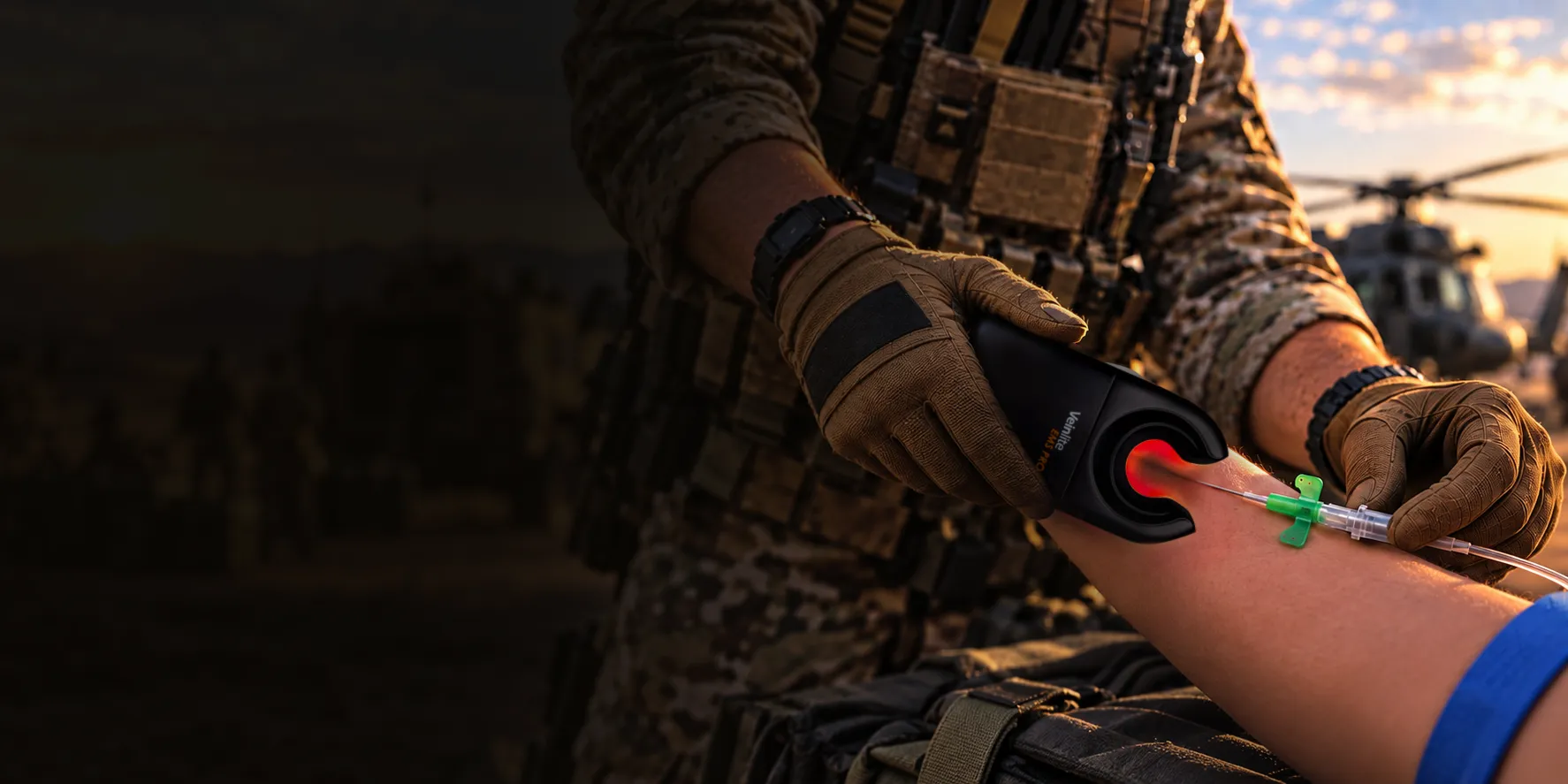 Field medic using a handheld vein visualization device near an IV-access site on a forearm